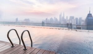 Rooftop infinity pool with a view of the Kuala Lumpur skyline at sunrise, illustrating the affordable luxury available when planning budget travel Malaysia.