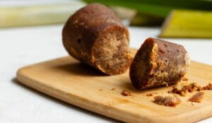 Close-up of an authentic cylindrical block of Gula Melaka from Melaka Malaysia on a wooden board.