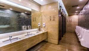 Interior of modern public toilets in Malaysia featuring clean sinks, mirrors, and white urinals in a luxury setting.