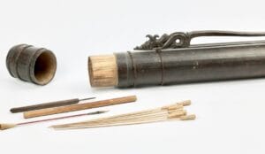 Modern Bamboo quiver and poison darts used for orang asli blowpipe hunting displayed on a white background.