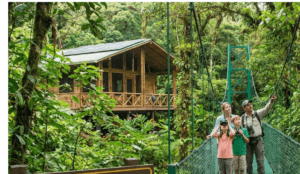 A family on a guided eco tourism tours excursion, using binoculars on a rainforest suspension bridge near a sustainable wooden cabin powered by solar panels.